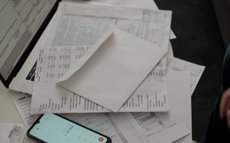 over-shoulder-shot-of-hands-of-unrecognizable-man-opening-envelope-taking-out-overdue--SBI-350445375