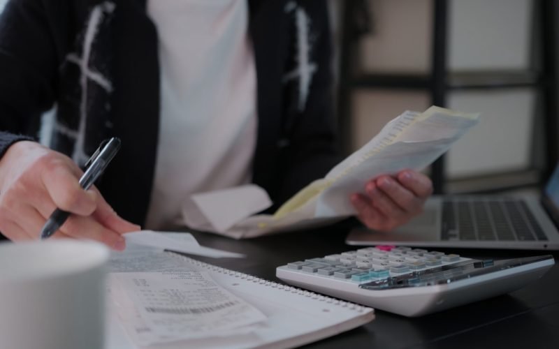 woman-checking-bills-taxes-bank-account-balance-and-calculating-expenses-in-the-living-SBI-350026552